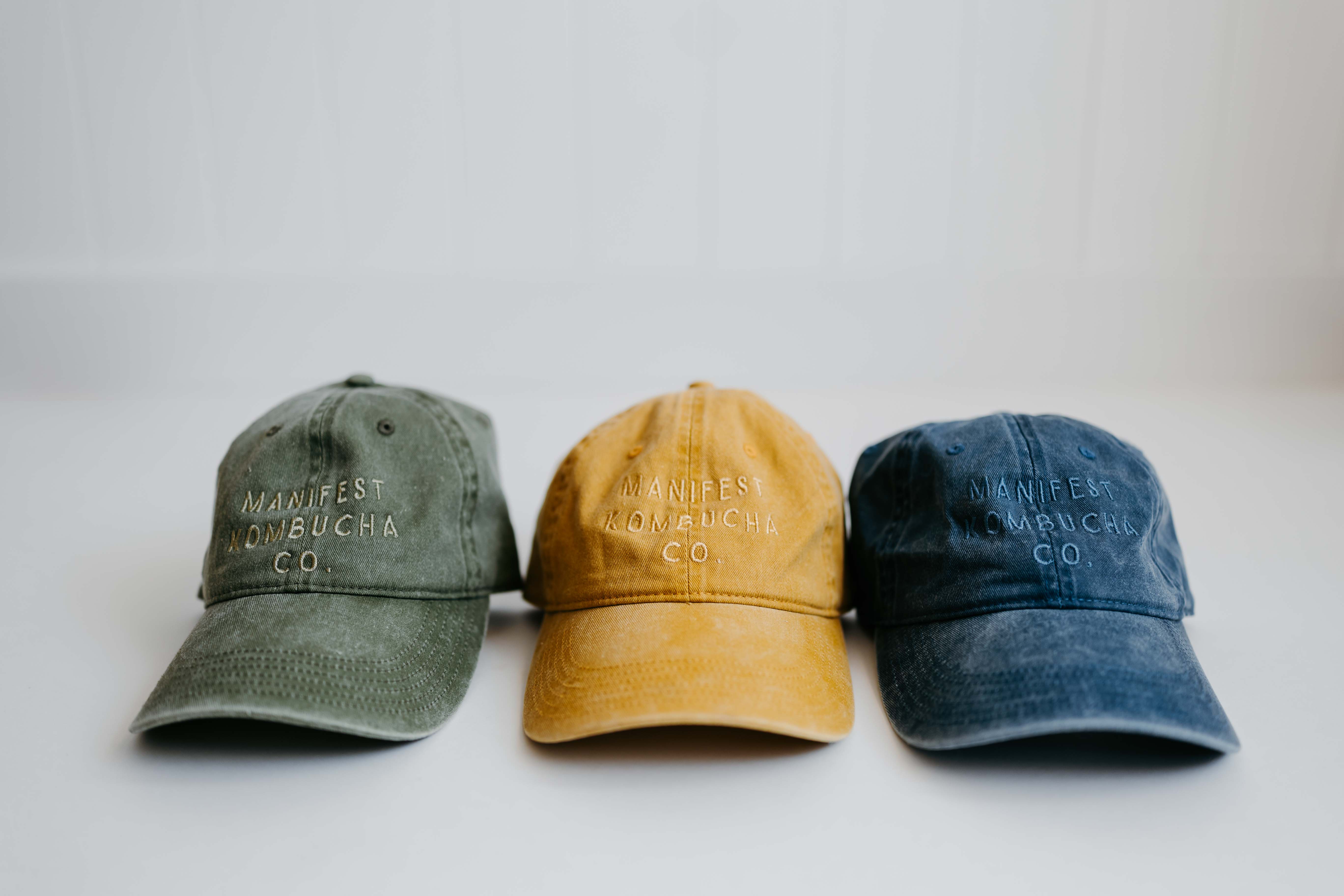 Manifest Kombucha hats in three colors